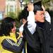 Pei Li Xia adjusts her son Yi Ren's hood outside of Rackham Auditorium for commencement on Friday morning. Melanie Maxwell I AnnArbor.com